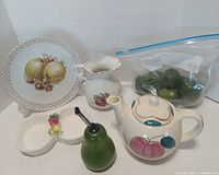 Front view of all ceramic pieces, grinder, and bag of faux limes