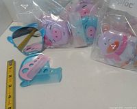 Open pig compact showing mirror and combs, bags of additional pig and penguin compacts behind