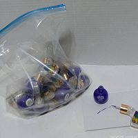 Bag of sealed purple Eye Calligraphy eyeliner bottles and one open sample (sample excluded)