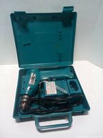 Drill in open Makita case showing cord and interior compartments