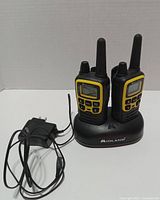 Two Midland T61VP3 radios on dual charging cradle with adapter cord attached