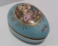 Closed egg-shaped trinket box showing exterior artwork and color