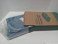 Box partially open showing teal heating pad inside plastic