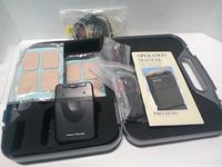 Opened carry case showing TENS 3000 unit, eight electrode pads, lead wires in bags and Operation Manual