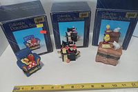 Three porcelain trinket boxes with their packaging for scale