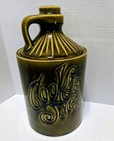 Front view of green McCoy cookie jug showing relief text and handle