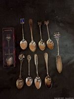 Group shot of boxed spoon, nine loose spoons and bread knife