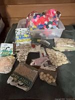 Overview of bin with pom-poms and various packaged craft items