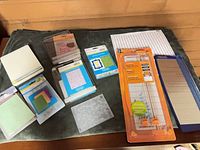 Group shot of embossing folders, paper trimmer, paper sheets