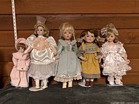 Front view of five porcelain dolls on stands