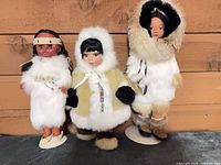 All three dolls standing against wood backdrop