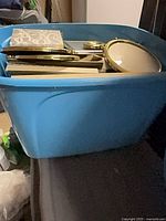 Blue plastic tote filled with assorted picture frames