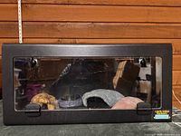 Front view of terrarium with hides and water dish visible