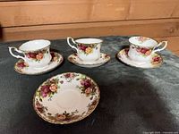 Three tea cups each on a saucer plus an extra saucer displayed