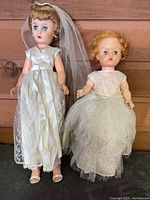 Two vintage bride dolls side by side showing full outfits