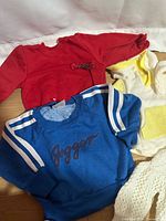 Overview of red, blue, cream and white baby garments