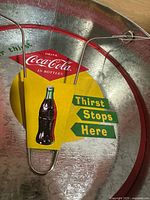 Top view of galvanized Coca-Cola plate holder showing interior graphic and wire insert