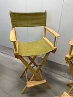 Front view of tall wood director chair with olive canvas seat/back and footrest