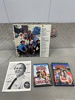 Group shot of vinyl LP, autographed photo, two DVD cases