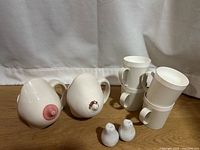 Lot overview showing two ceramic novelty mugs, four white plastic stacking mugs, two bird salt & pepper shakers