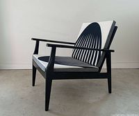 Side view of lounge chair showing black frame and Op Art upholstery