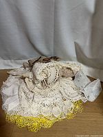 Pile of assorted crocheted doilies on wooden surface