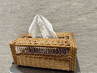 Rattan tissue box cover on table with tissue inserted