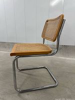 Side profile of chair showing chrome cantilever frame and cane seat/back