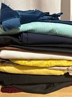 Stack of assorted fabrics showing variety of colors and textures