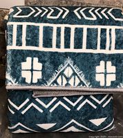 Folded dark teal carpet runner with white geometric design in packaging