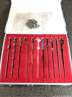 Open box showing 11 wands in red insert and bagged keychain