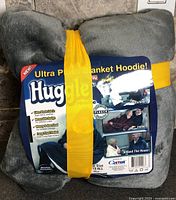 Packaged grey Huggle blanket hoodie front label