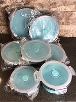 Full set of seven turquoise collapsible containers in packaging