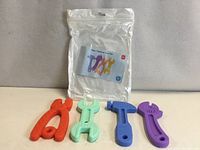 Set of four silicone tool-shaped teething toys with storage bag