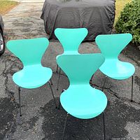 Full view of four aqua Fritz Hansen Series 7 chairs on driveway