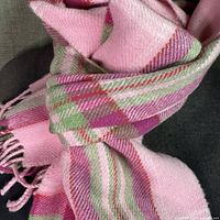 Close-up of pink and green plaid scarf fabric and fringe