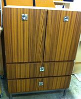 Front view of wood veneer armoire with doors and drawers