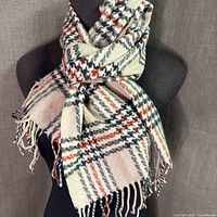 Full view of scarf draped on form showing overall pattern and fringe