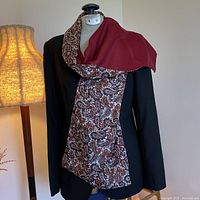Full view of scarf draped on mannequin showing paisley front and burgundy wool back