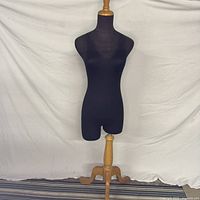 Front view of navy dress form on wood tripod base