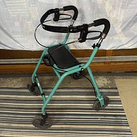 Side view showing frame color, seat flipped up, handles, brakes, wheels