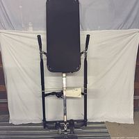 Full view of inversion table upright against backdrop