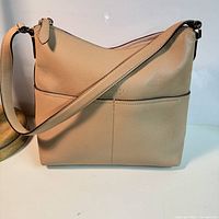 Front view showing overall bag shape, strap, exterior pocket