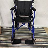 Front view of blue Medline transport chair showing footrests and frame