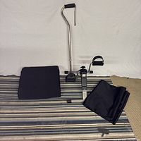 All four items laid out: seat cushion, cane, pedal exerciser, transfer sheet
