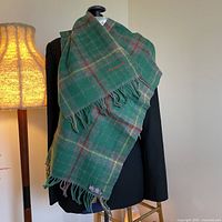 Scarf draped over mannequin with lamp, showing pattern and fringe