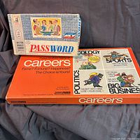 Closed boxes of Password and Careers board games stacked