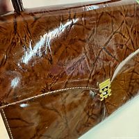 Close view of glossy marbled brown surface of handbag
