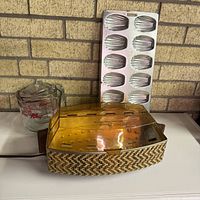 Salton bun warmer, one Fire-King measuring cup, and Madeleine tray grouped together