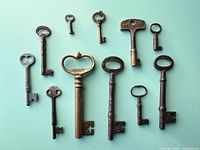 Group layout of 11 antique skeleton keys on aqua background
